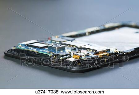 Stock Photo - Disassembled mobile phone in the service centre with internal components of the camera and speaker.. Fotosearch