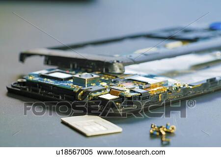 Stock Photography - Disassembled mobile phone in the service centre with internal components of the camera and speaker.. Fotosearch