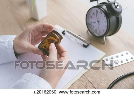 Doctor holding unlabelled bottle of pills. View Large Photo Image Stock Image - Doctor holding unlabelled bottle of pills.. Fotosearch