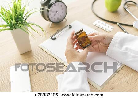 Doctor holding unlabelled bottle of pills. View Large Photo Image Stock Photography - Doctor holding unlabelled bottle of pills.. Fotosearch