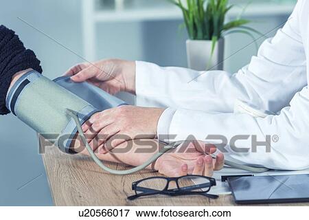 Stock Photo - Doctor measuring blood pressure.. Fotosearch