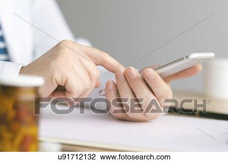 Stock Image - Doctor using smartphone.. Fotosearch