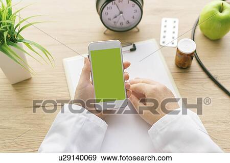 Stock Photo - Doctor using smartphone.. Fotosearch
