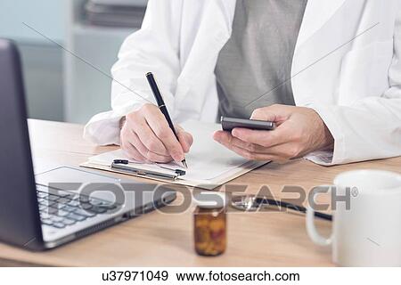 Stock Photo - Doctor using smartphone.. Fotosearch