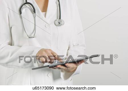 Stock Image - Doctor using tablet computer.. Fotosearch