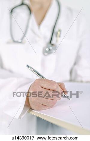 Stock Photo - Doctor writing on clipboard.. Fotosearch
