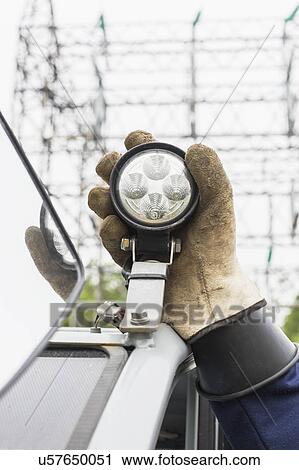 Engineer adjusting work light on vehicle. View Large Photo Image Stock Image - Engineer adjusting work light on vehicle.. Fotosearch