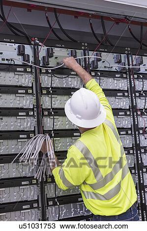 Stock Image - Engineer connecting energy storage batteries for backup power to an electric power plant.. Fotosearch