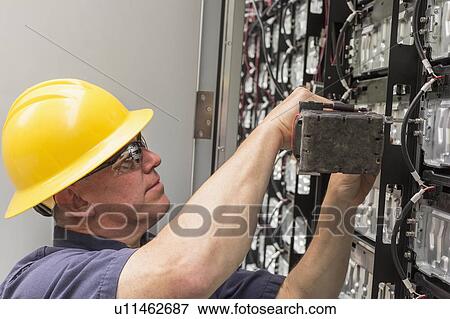 Engineer connecting energy storage batteries for backup power to an electric power plant. View Large Photo Image Stock Photo - Engineer connecting energy storage batteries for backup power to an electric power plant.. Fotosearch
