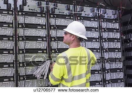 Stock Photo - Engineer connecting energy storage batteries for backup power to an electric power plant.. Fotosearch