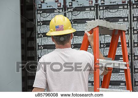 Stock Photo - Engineer connecting energy storage batteries for backup power to an electric power plant.. Fotosearch