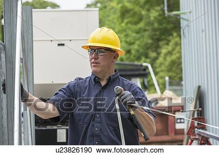 Stock Image - Engineer preparing to pull cable.. Fotosearch