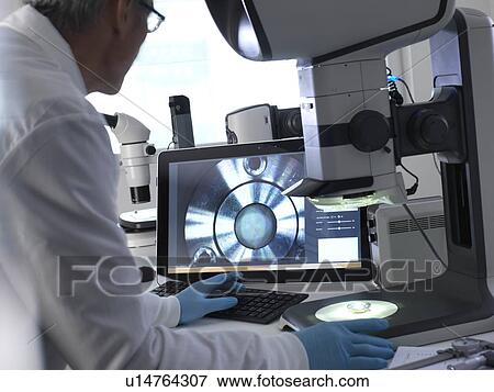 Engineer using a stereo microscope to inspect a manufactured component during the quality control process. View Large Photo Image Stock Photo - Engineer using a stereo microscope to inspect a manufactured component during the quality control process.. Fotosearch