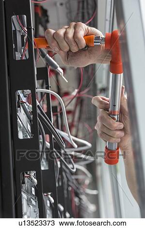 Stock Image - Engineer using a torque wrench on copper bolts.. Fotosearch
