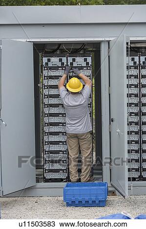 Stock Image - Engineers connecting energy storage batteries for backup power to an electric power plant.. Fotosearch