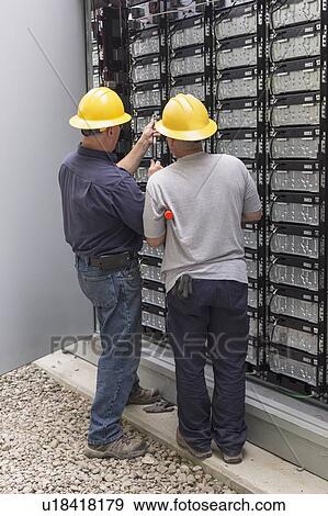 Stock Photo - Engineers connecting energy storage batteries for backup power to an electric power plant.. Fotosearch