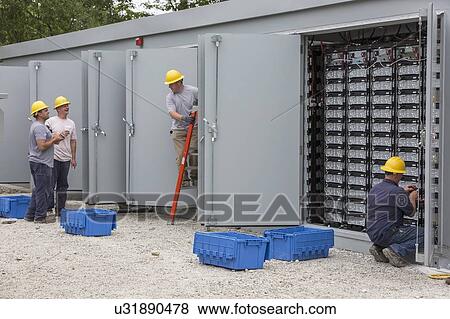 Stock Photo - Engineers connecting energy storage batteries for backup power to an electric power plant.. Fotosearch