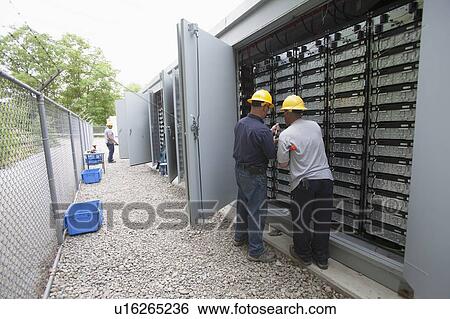 Stock Photograph - Engineers connecting energy storage batteries for backup power to an electric power plant.. Fotosearch