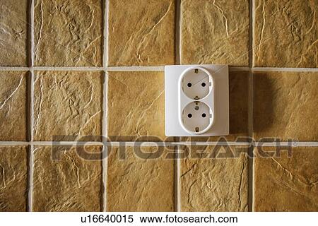 Stock Photography - European electrical sockets in kitchen wall with ceramic tiles.. Fotosearch