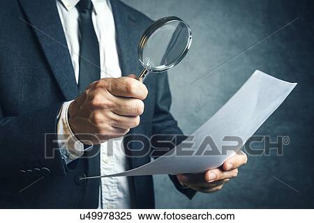 Stock Photography - Examining small print, conceptual image.. Fotosearch