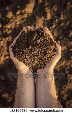 Stock Photo - Farmer holding pile of soil.. Fotosearch