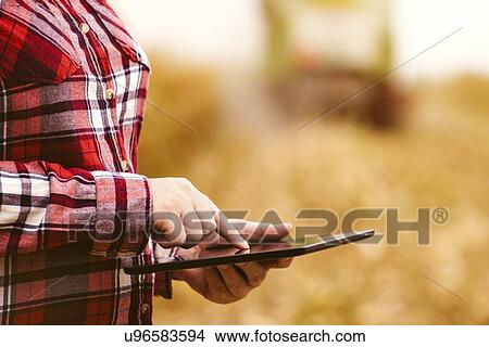 Farmer using digital tablet. View Large Photo Image Picture - Farmer using digital tablet.. Fotosearch