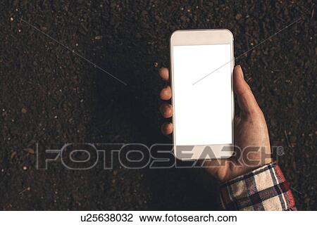 Stock Image - Farmer using smartphone.. Fotosearch