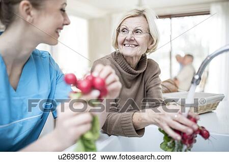 Female care worker washing radishes with senior woman. View Large Photo Image Stock Image - Female care worker washing radishes with senior woman.. Fotosearch