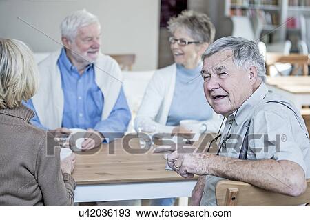 Friends talking and smiling in retirement home. View Large Photo Image Stock Image - Friends talking and smiling in retirement home.. Fotosearch