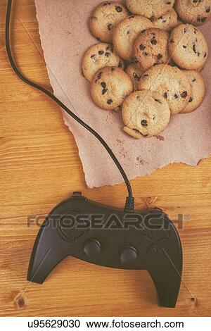 Stock Image - Gamepad controller with cookies.. Fotosearch