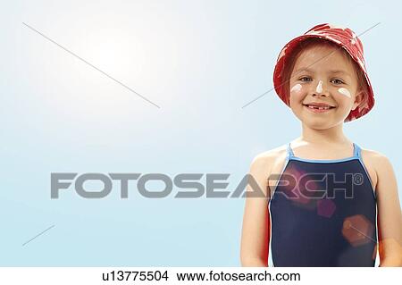 Picture - Girl wearing sunhat and suncream, portrait.. Fotosearch