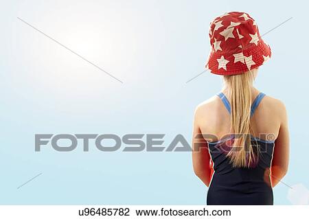 Stock Image - Girl wearing swimsuit and sunhat, rear view.. Fotosearch