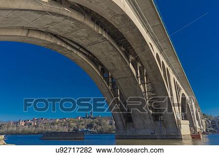 Stock Image - Key Bridge and Georgetown in background is seen on the Potomac River, Washington D. C.. Fotosearch