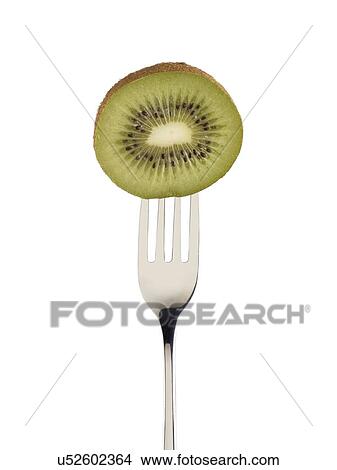 Picture - Kiwi cut in half on a fork.. Fotosearch