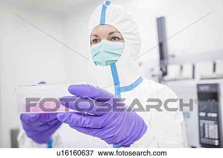 Stock Photo - Lab technician carrying a cell-based testing kit in a laboratory that engineers human tissues for implant. Such implants include bone and skin grafts.. Fotosearch