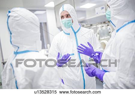 Lab technicians wearing protective suits and face masks in a laboratory that must maintain a sterile environment. View Large Photo Image Stock Photography - Lab technicians wearing protective suits and face masks in a laboratory that must maintain a sterile environment.. Fotosearch