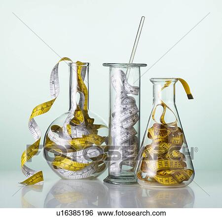 Stock Photograph - Laboratory glassware with tape measures.. Fotosearch