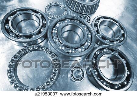 Stock Photo - Large ball bearings and small pinions against brushed aluminum background.. Fotosearch