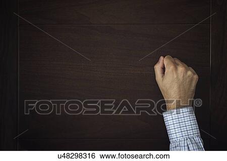 Stock Photograph - Male hand knocking on wooden door.. Fotosearch