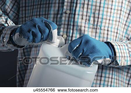 Stock Photograph - Man holding plastic canister.. Fotosearch