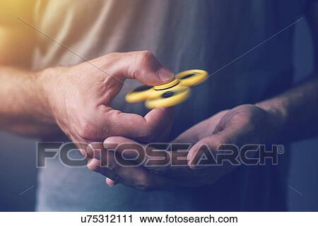Man playing with fidget spinner. View Large Photo Image Stock Image - Man playing with fidget spinner.. Fotosearch