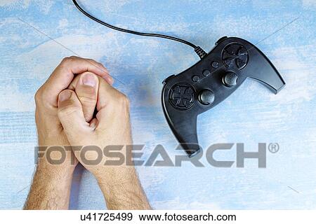 Stock Photo - Man resisting video game addiction, conceptual image.. Fotosearch