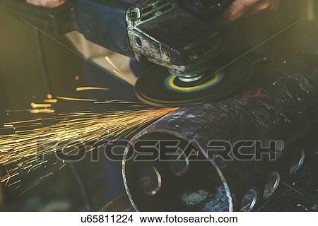 Picture - Man using metal grinder.. Fotosearch