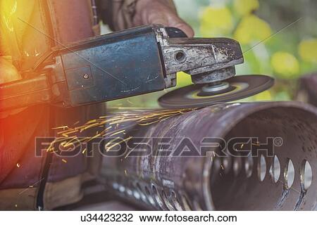 Stock Image - Man using metal grinder.. Fotosearch