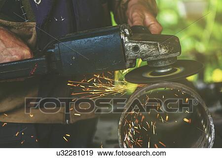 Stock Photo - Man using metal grinder.. Fotosearch