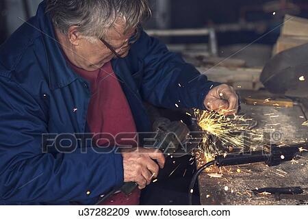 Stock Photo - Man using metal grinder.. Fotosearch