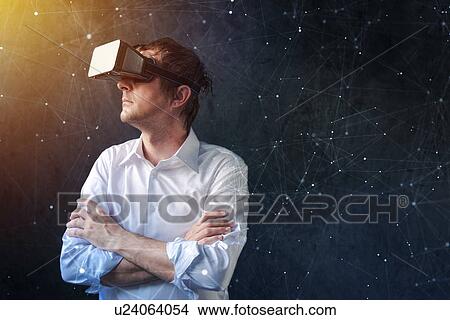 Picture - Man with VR headset exploring virtual reality.. Fotosearch