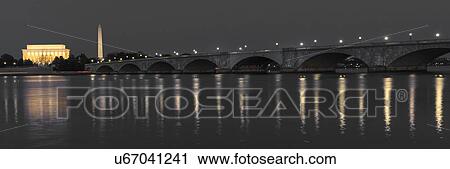 Stock Image - Memorial Bridge at dusk blue-hour spans Potomac River and features Lincoln Memorial and Washington Monument. Fotosearch