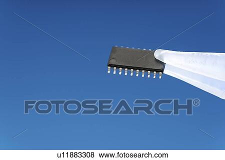 Stock Photo - Microchip held between tweezers.. Fotosearch