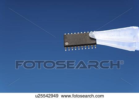 Stock Photo - Microchip held between tweezers.. Fotosearch
